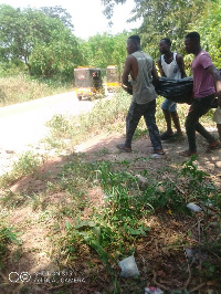 The remains of the suspect being carried by some residents