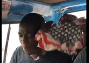 Pastor being shielded by a woman during the fight in a trotro