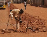 The disabled man digging with a pickaxe