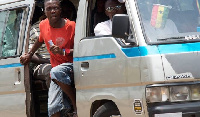 File photo: A bus conductor (trotro mate) about his work