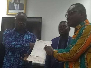 Okatakyie Amankwaa Afrifa presenting the cheque to Lands Minister Kwaku Asomah-Cheremeh