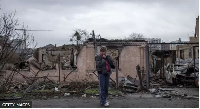 Woman dey survey wreckage of Bucha near Kyiv