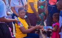 Salma Mumin giving out a pack of food to one of the children