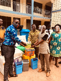 Headmaster of the school, Mr. Amo Brenya receiving the items