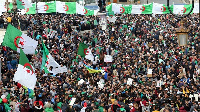 Demonstrators carry flags and banners during an anti-government protest in Algiers.