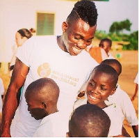 Newcastle winger Christian Atsu hugging a group of children