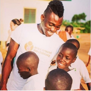 Newcastle winger Christian Atsu hugging a group of children