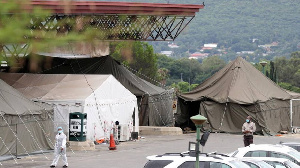 A health worker walks past tents erected at the parking lot of the Steve Biko Academic Hospital