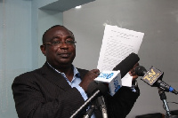 Mr Augustine Niber holding a copy of the report