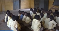 Pupils at Boti Saint Philips Basic School in Yilo Krobo sitting on wood slabs during classes