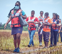 Daisy Mina Antwi (in front) leading her team of GLP volunteers into Nzulezu