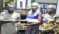 Alice Bonye receiving the donation from a staff of Crime Check TV