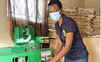 Wada Kealotswe trims a pencil using a cutting machine... Photo by Sharon Tshipa/Xinhua)