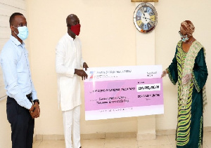 Sophia Akuffo, Chairperson of the Board of Trustees of the Trust Fund receiving the check