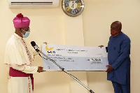 Archbishop Palmer-Buckle presenting the cheque to Mr. Jude Kofi Bucknor