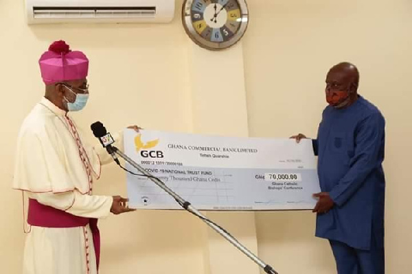 Archbishop Palmer-Buckle presenting the cheque to Mr. Jude Kofi Bucknor