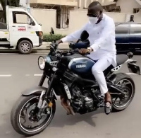 Dr. Osei Kwame Despite on a motorbike