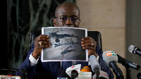 Public prosecutor Richard Adou holds a picture during a news conference in Abidjan, Ivory Coast