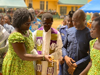 Dr. Dominic Eduah joined by a priest and the headmistress to commission the project