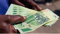 A man shows a wad of the new Zimbabwe two-dollar notes he received from a bank in Harare