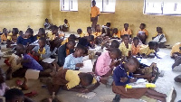 Pupils of Guo D/A Primary School sit on the bare floor at school