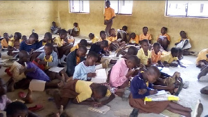 Pupils of Guo D/A Primary School sit on the bare floor at school