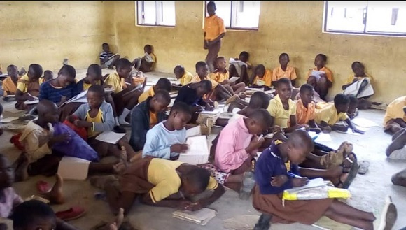 Pupils of Guo D/A Primary School sit on the bare floor at school