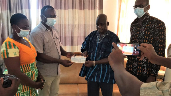 Stephen Yakubu presenting the cheque to Mr Adda's family