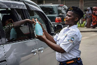 A security officer dispenses chlorinated water to a passenger at Muhimbili National Hospital in Dar