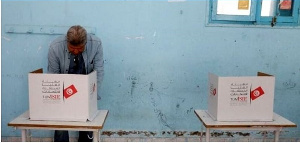 A man votes at a polling station during parliamentary election in Tunis