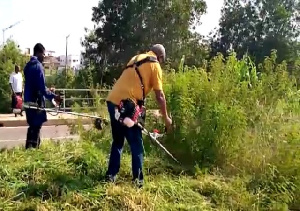 Former President Mahama with a back mount weeding machine