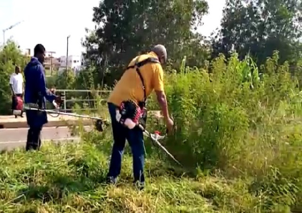 Former President Mahama with a back mount weeding machine