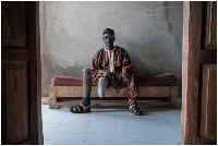 Boubacar Ba sits on a bench at the Senegalese Association of Mine Victims