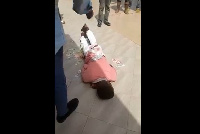 The young man laid on the floor as the customer sprayed money on him and blessed him