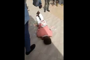 The young man laid on the floor as the customer sprayed money on him and blessed him