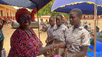 Abla Dzifa Gomashie giving out sanitary pads to school girls