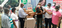 Dr. Ako Akoto-Ampaw(left) receiving the donations from the Adonko group.