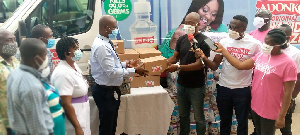 Dr. Ako Akoto-Ampaw(left) receiving the donations from the Adonko group.