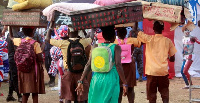 Some Students carrying their luggage to school