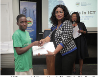 Ms. Olivia Okailey Quartey presenting a laptop to one of the girls