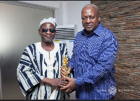 Dr. Henry Seidu Danaa presents an award to former President John Mahama