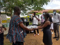 Nana Nkweifi VIII presenting the items to the AAK District Health Director, Gifty Ankrah