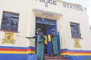 Health workers spray disinfectant on the walls of Elburgon Police Station