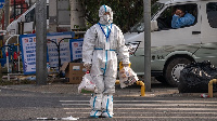 A worker wearing protective gear near an area placed under lockdown due to Covid-19 in Beijing