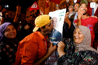 Supporters of Tunisian President Kais Saied, celebrate as exit poll shows Saied won