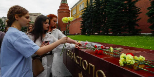 People lay flowers as tribute to the victims of Sunday's attack