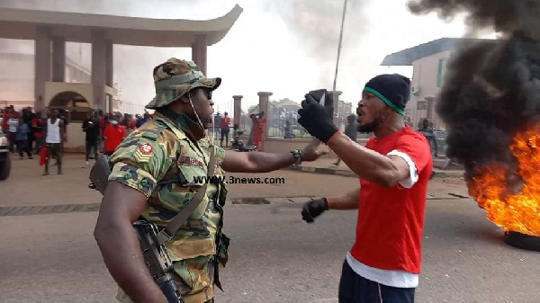 A protestor talking to a military officer