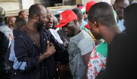 A member of the Agbogbloshie boys [with a red cap] being held to restore calm