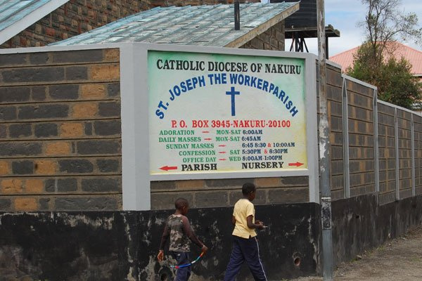 Children walk past St Joseph The Workers Catholic Parish Church in Racetrack Estate in Nakuru Town