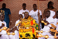 Otumfuo Osei Tutu II dressed in his royal regalia, seated in state